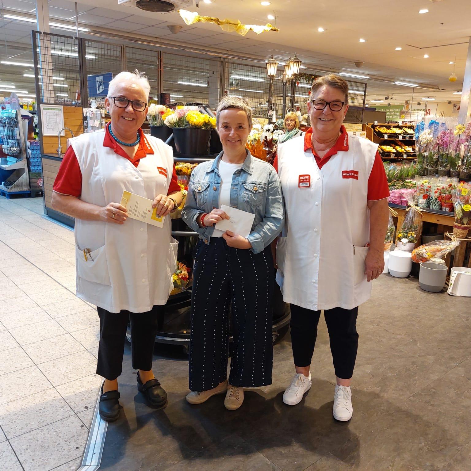 Spendenübergabe bei Rewe Rudel anlässlich 30 jähriges Jubiläum (v.l.n.r.: Annemarie Rudel/Geschäftsführerin, Silke Kastner/Hospizverein Bamberg, Frau Langer/Marktleitung)